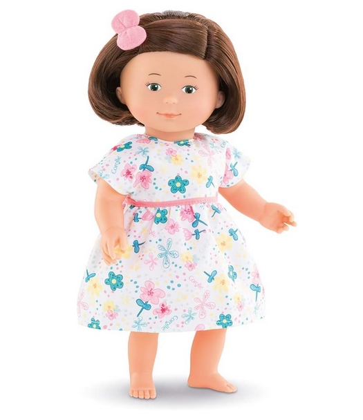 Florolle Églantine is 13-inch soft body doll shown here in a standing position. She has silky, rooted hair styled in a bob, a playful look in her hazel painted eyes and a cheerful smile. Dressed in a floral-print dress and with a matching scrunchie in her hair. 
