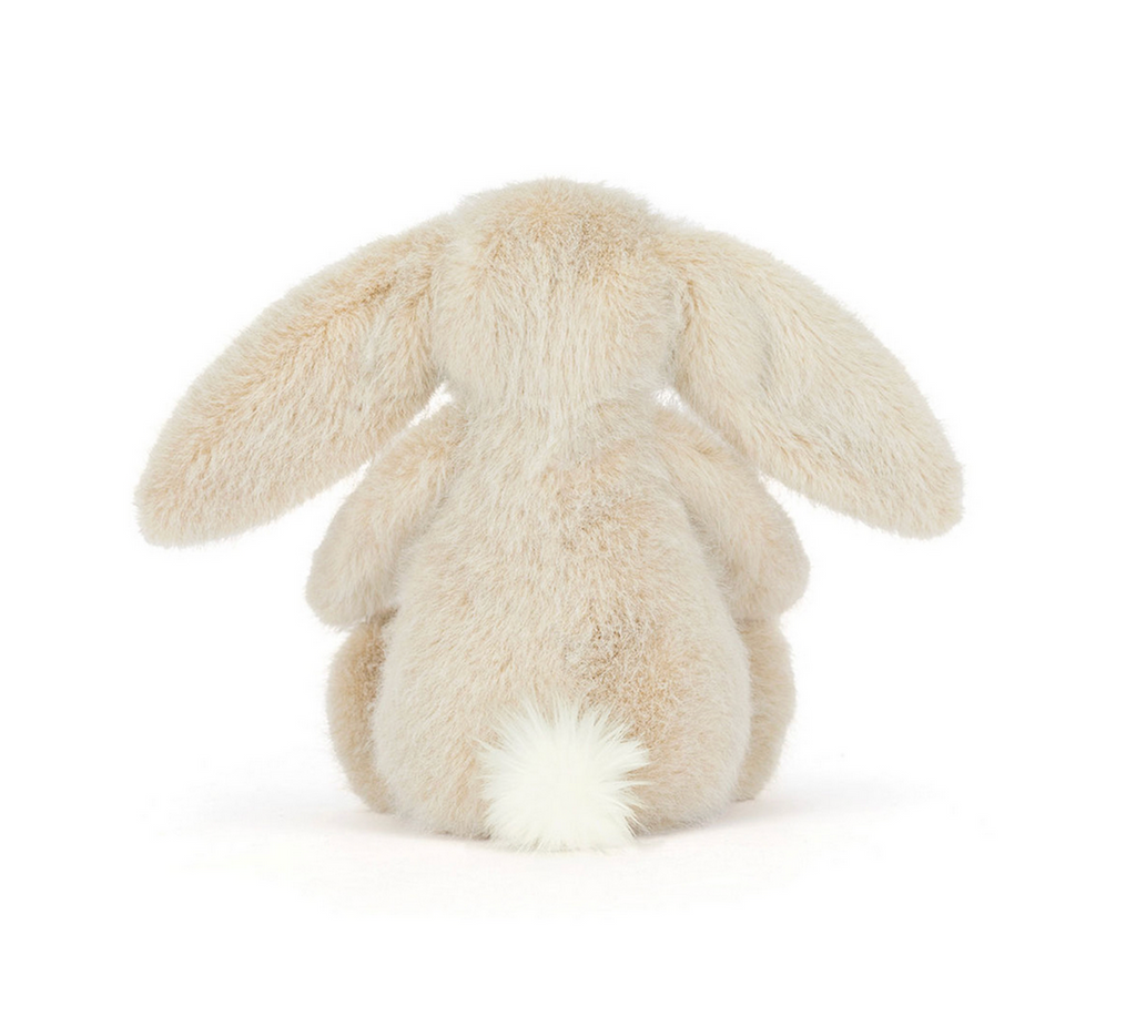 Plush Flofflet Bunny in wheat sitting up and facing the back to show off the fluffiest white cottontail. 