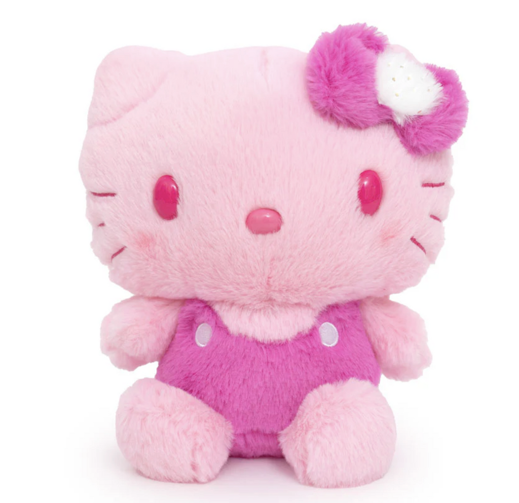 Fluffy pink Hello Kitty stuffed animal with fuzzy fur wearing overalls and a pink and white bow. 