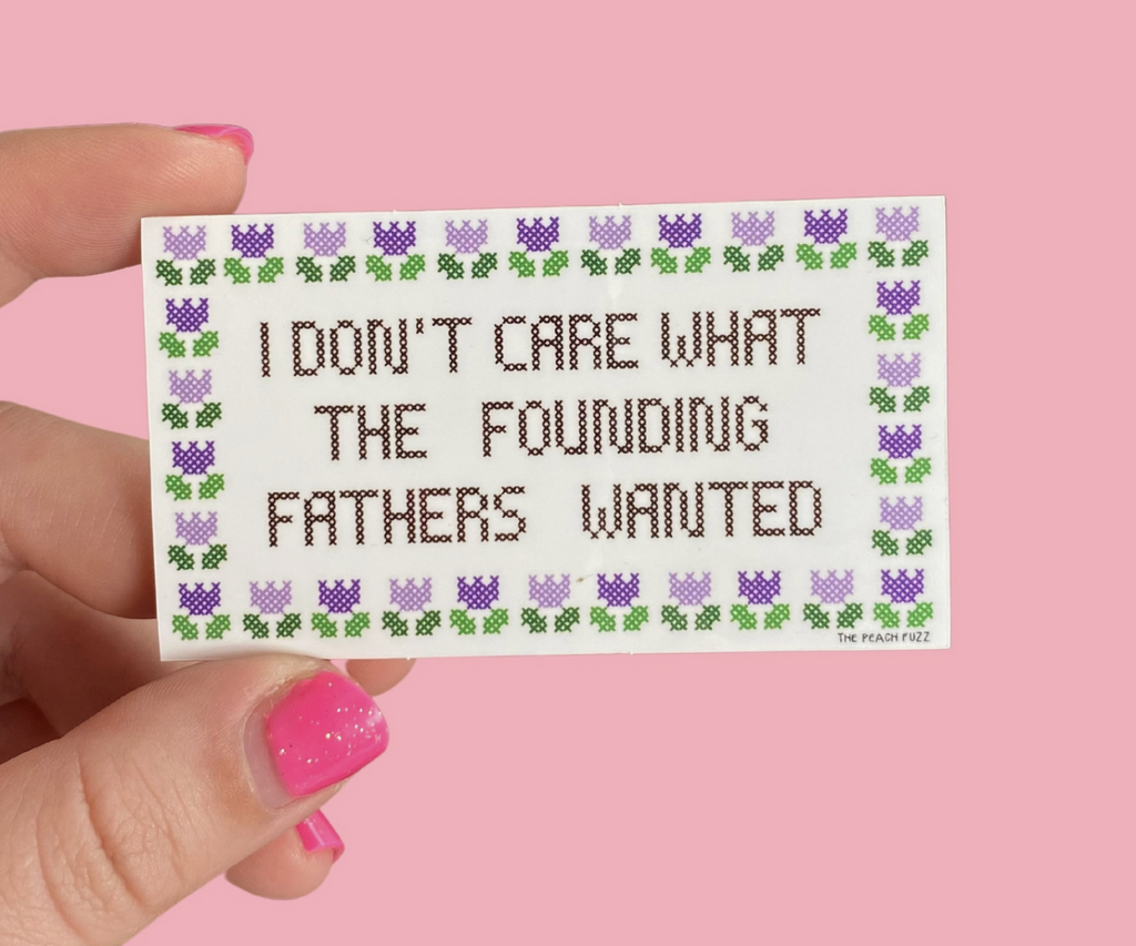 Rectangle sticker that looks like it is cross stitch and reads "I Don't Care What The Founding Fathers Wanted" 