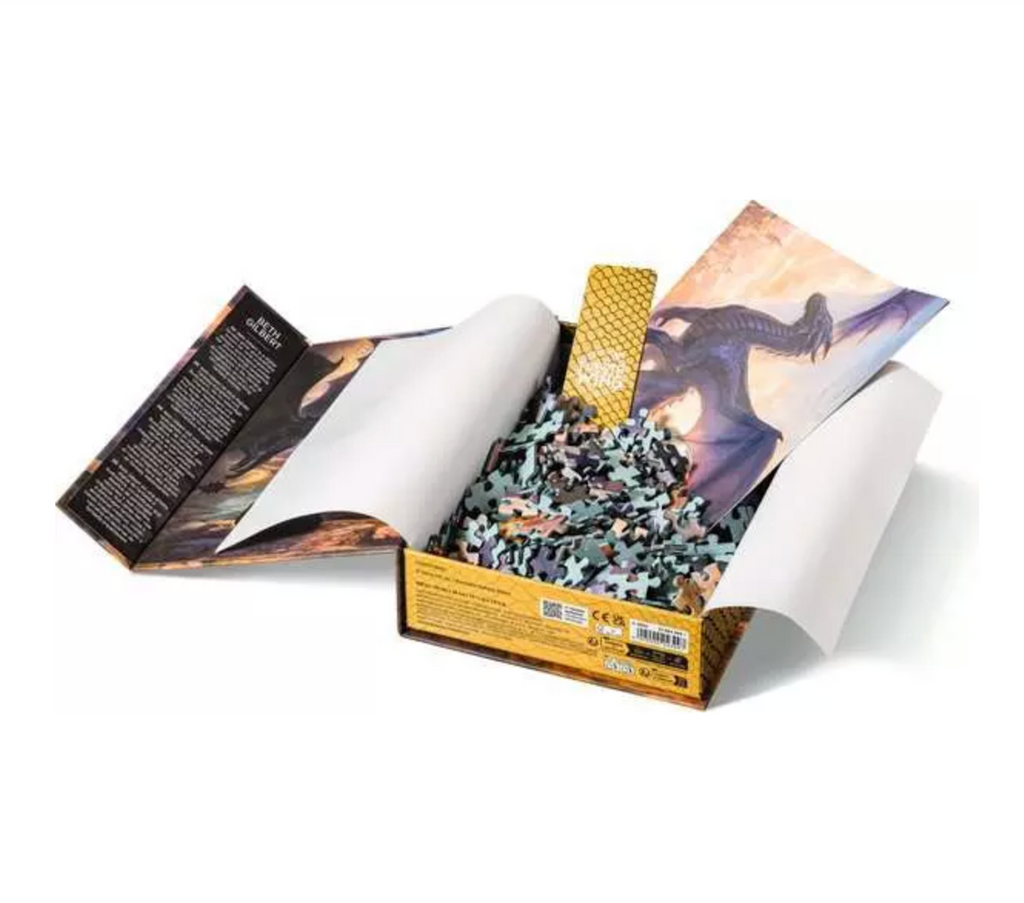 A beautiful gift box opened to show the puzzle pieces, bookmark and poster that come with the Fourth Wing 500 Piece Puzzle. 