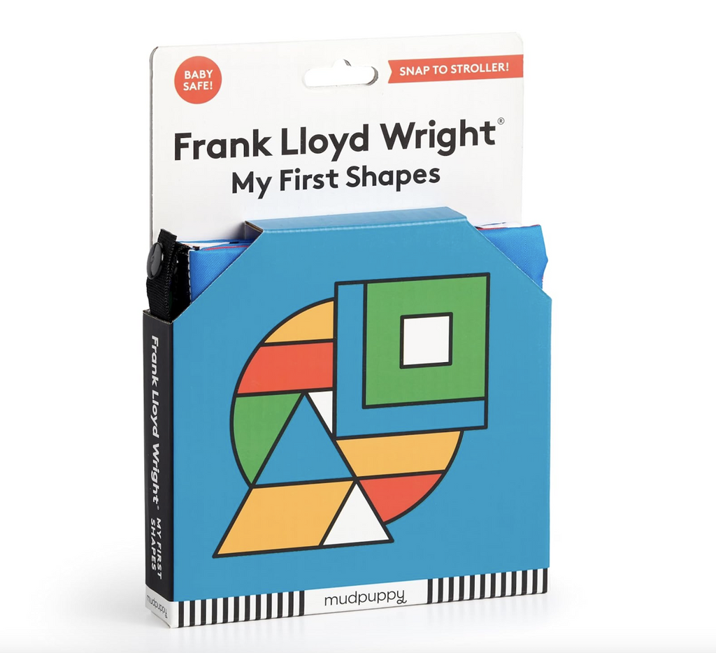 The Frank Lloyd Wright My First Shapes Crinkle Fabric Stroller Book packaged in a box with colorful geometric shapes on the cover as well open corners so the crinkly fabric and soft texture can be felt. 