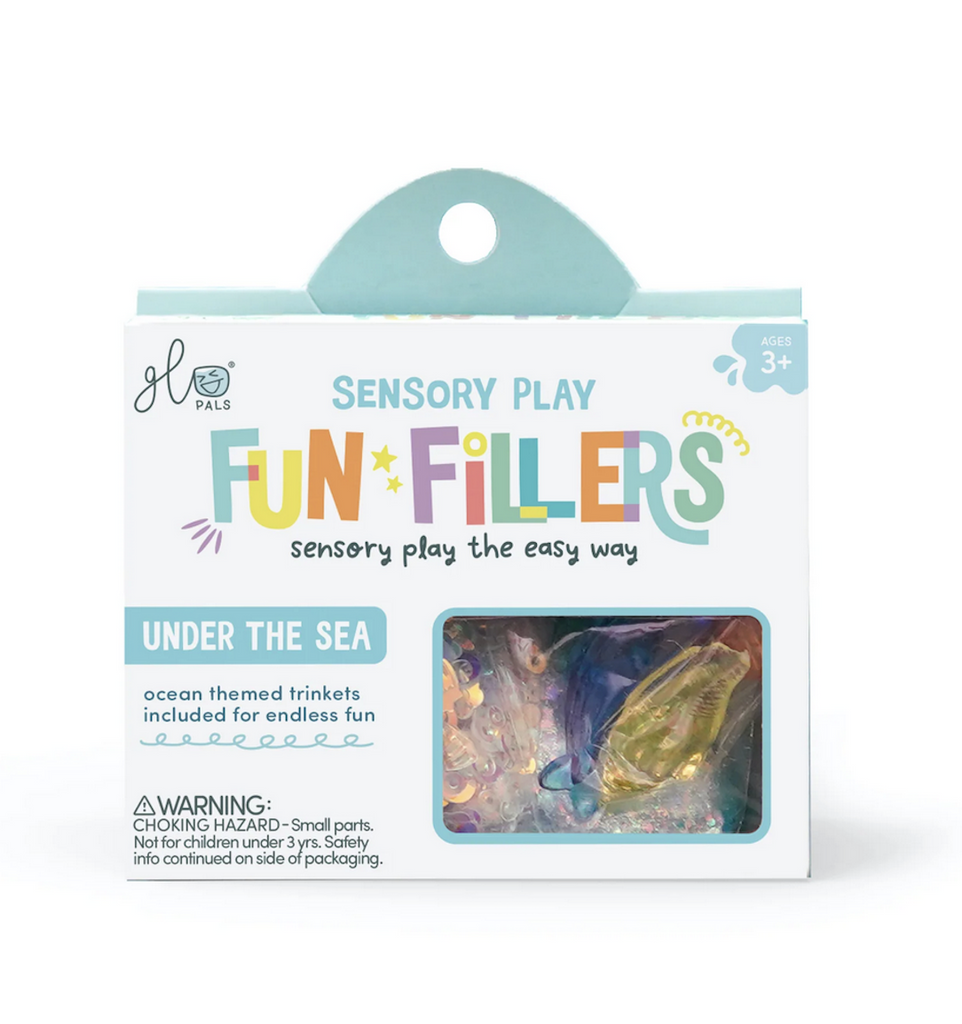White box with colorful lettering containing Under the Sea ocean themed trinkets to use with the Sensory Play Jars. 