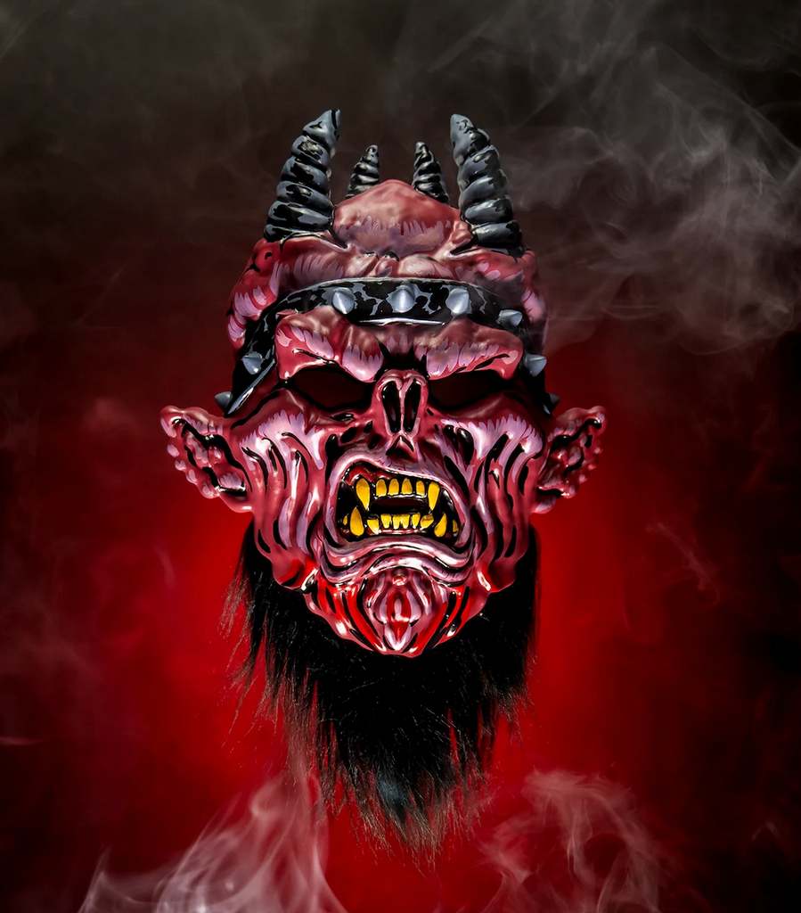 Oderus Urungus from the band GWAR molded plastic mask on a smoky, red background. 