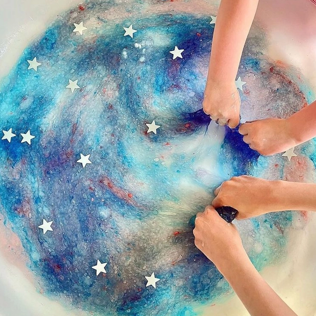 Galaxy slime colored with blue and purple with glow in the dark stars mixed in. 