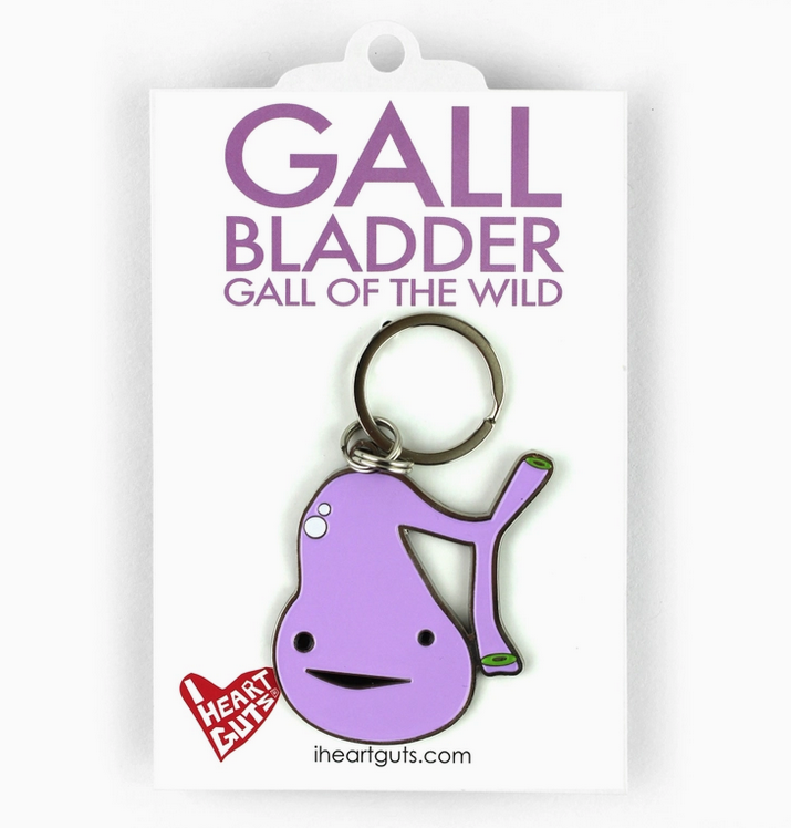 Purple Gall bladder enamel keychain packaged on a white backing card with purple lettering that reads "Gall Bladder Gall of the Wild" . 