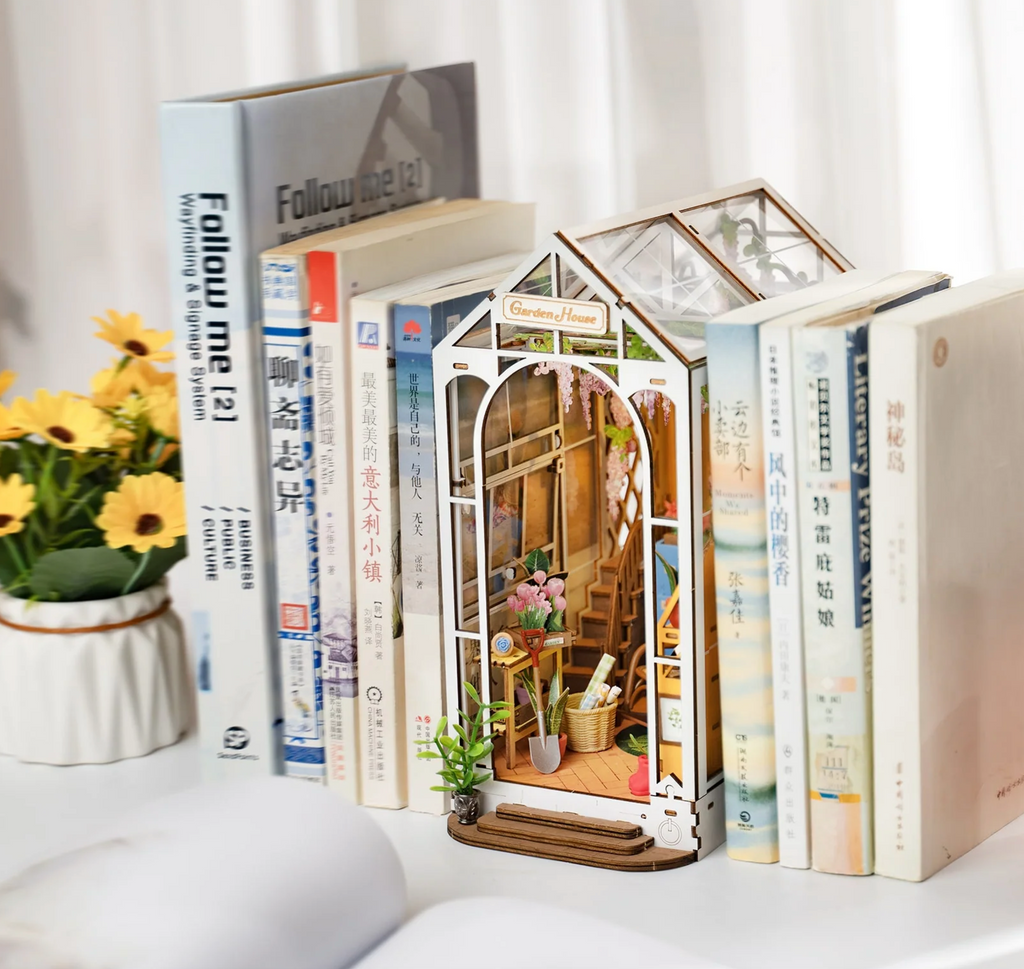 Garden House Book Nook on a shelf in between books.