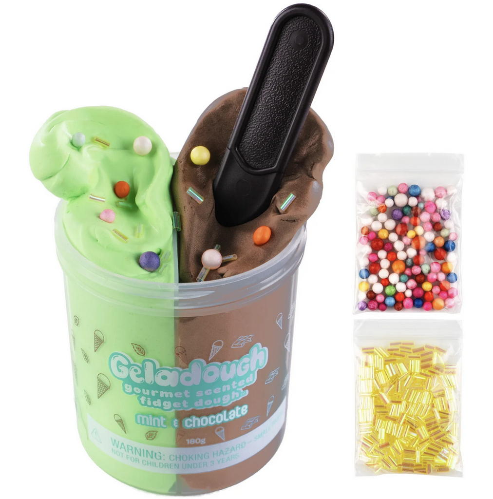 A clear container full of green mint scented dough and brown, chocolate scented dough. To the side are two bags with mix ins of multicolored beads and shiny gold bingsu beads. Not food, do not eat. 