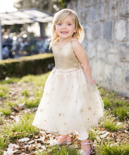 A young child wearing the Glam Party Gold Dress. 