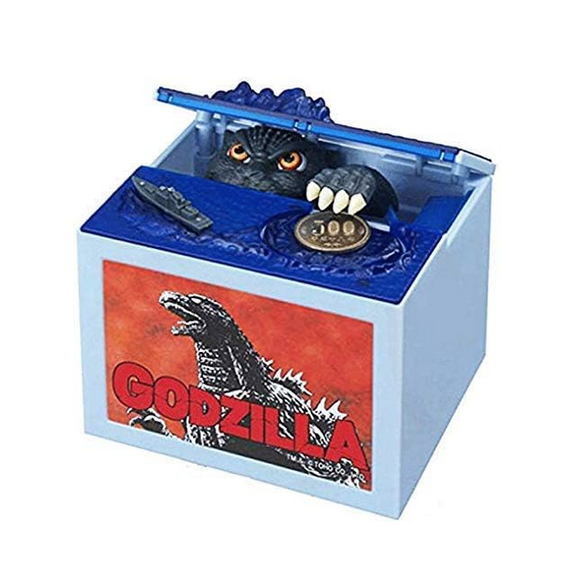 Light blue box with a picture of Godzilla on a red background on the front. The top has a lid lifting up with a Godzilla figure emerging from water and reaching for a coin.