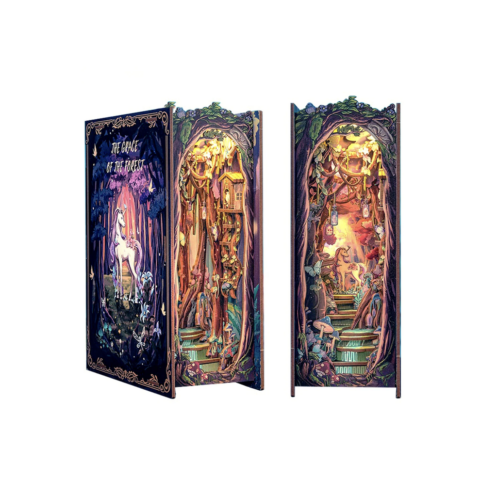 The Grace of the Forest Miniature Book Nook model kit turned slightly to the side to show the 3d features and another kit pictured straight on showing the magical unicorn at the top of rocky steps under a canopy of trees. 