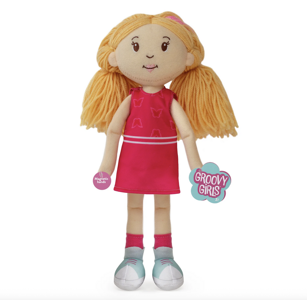 Groovy Girls Doll Rose, a plush baby doll with blonde yarn hair wearing a pink dress, pink socks and tennis shoes. 