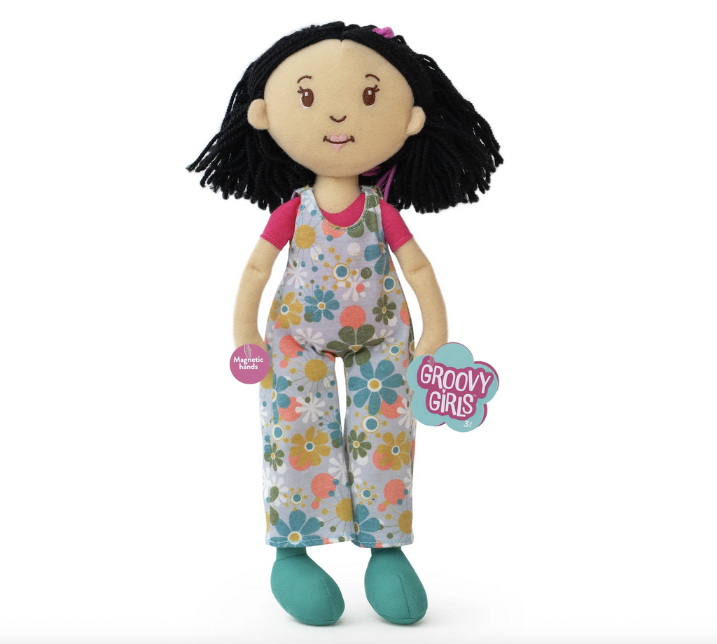 Groovy Girls doll Daisy plush doll who has shoulder length black hair, and is wearing floral patterned overalls. 