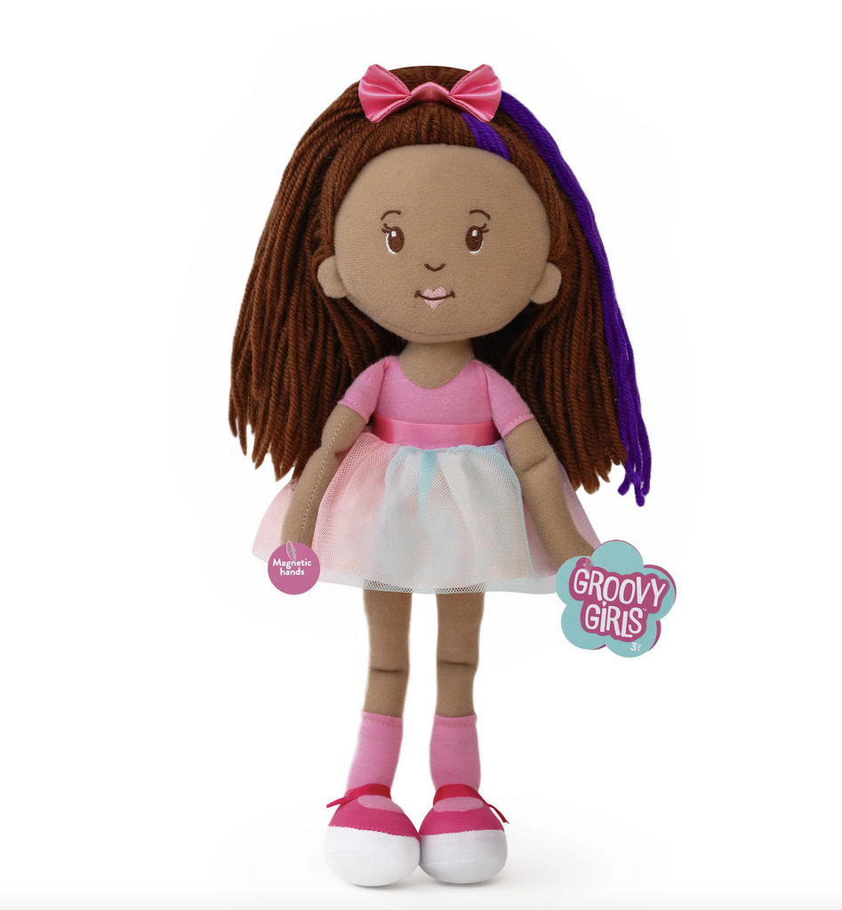 Plush Groovy Girls doll Iris wearing her colorful tutu, with a bright pink bow in her dark brown hair. 