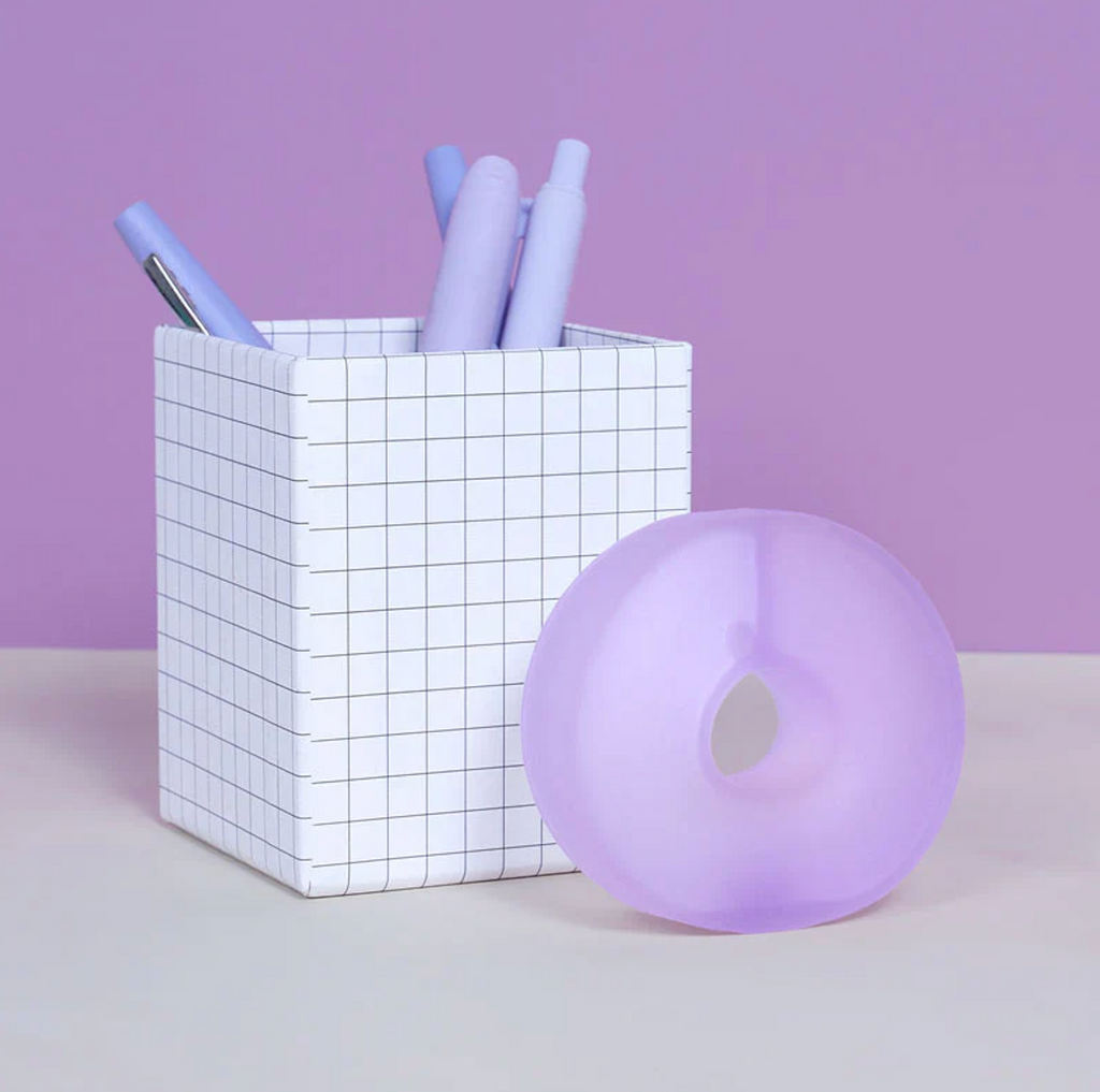 The Gump Loop stress toy on a desk beside a pen cup full of pens. 