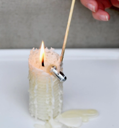 Burning candle showing a capsule that has been revealed while burning. 