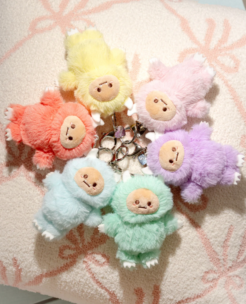 Pastel Hank Yeti Blind Box Bag Charms arranged in a circle. Including a yellow, orange, blue, green, purple and pink plush charm. Each sold individually, blind box style. 