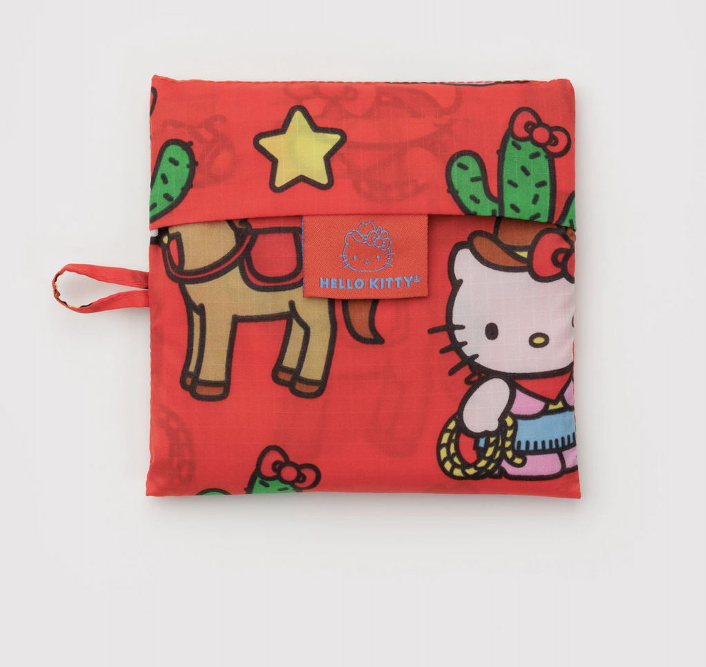 The Hello Kitty Western patterned standard Baggu bag folded into the flat 5x5 pouch it is stored in. 