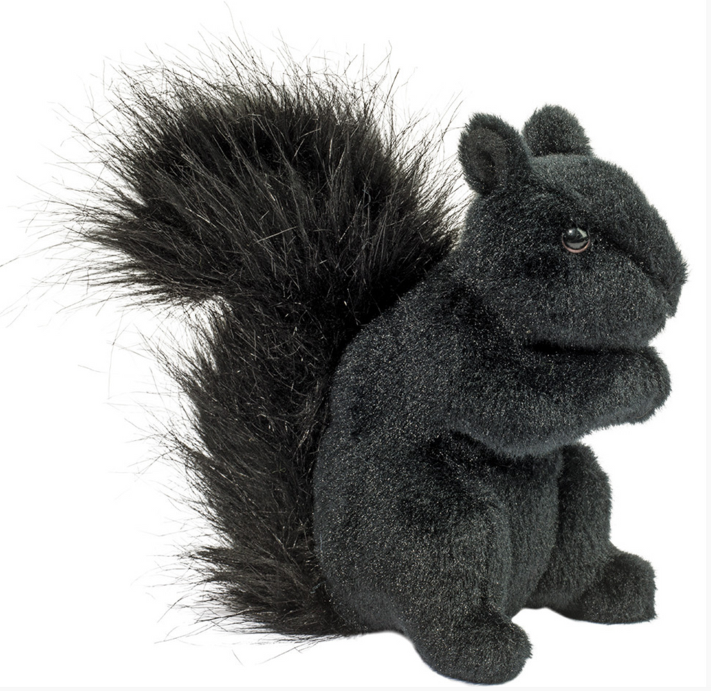 Completely black plush squirrel sitting up with it's bushy tail fluffed out behind him. 