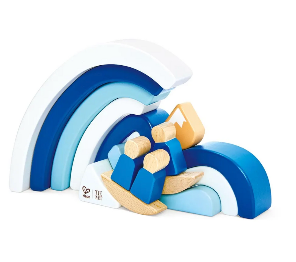 Wooden blocks in various shapes and in tones of blue, white and natural wood placed together in a manner that brings to mind The Great Wave by Hokusai. 