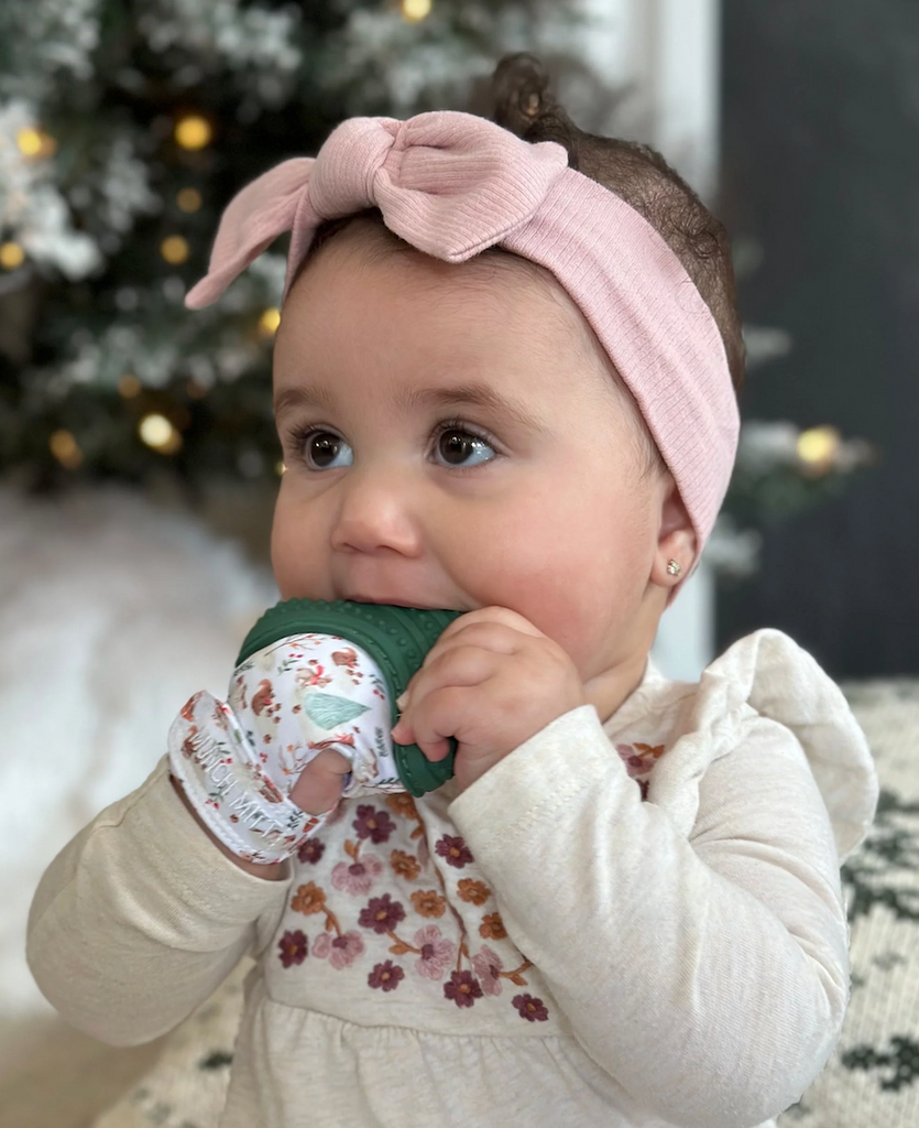 A sweet little baby chewing on the Holiday Munch Mitt. 