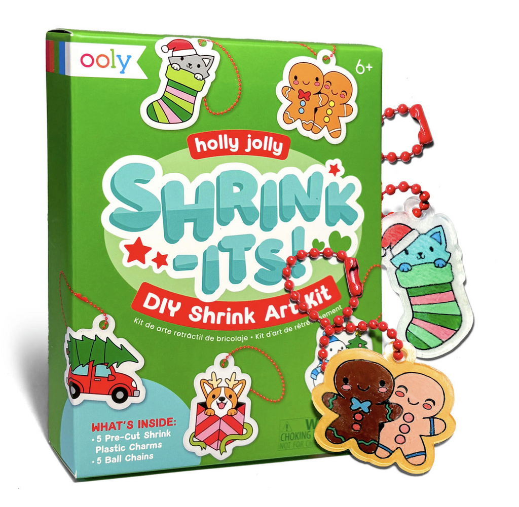 The Holly Jolly Shrink It's DIY Shrink Art Kit packaged in a green box with illustrated examples of the pre-cut shrink charms that are included in the kit. 