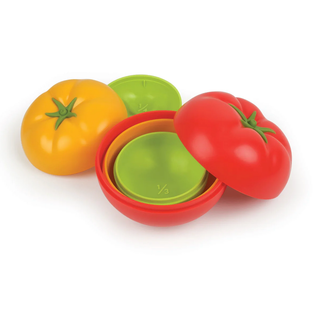 Set of colorful tomato-shaped measuring cups with red, yellow and green tomatoes. 