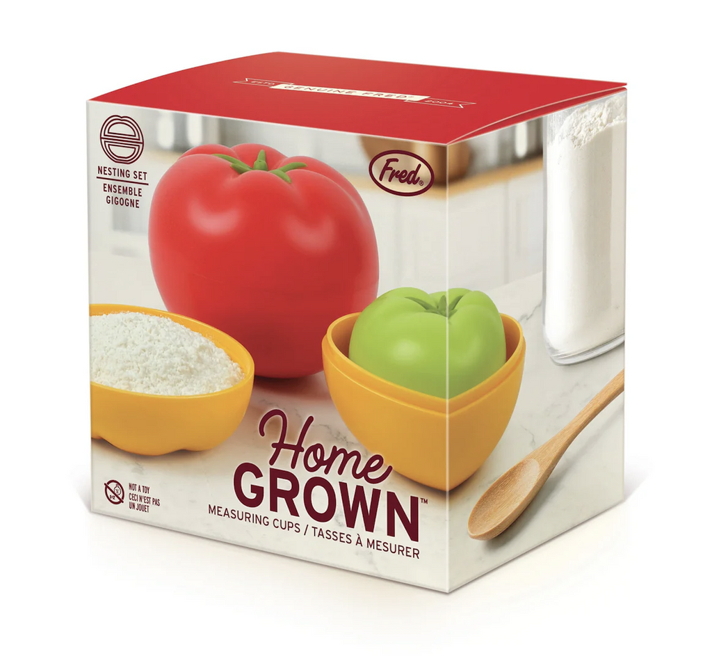 Home Grown Measuring cups packaged in a box with a colorful picture of the tomato shaped measuring cups in use with a red top. 