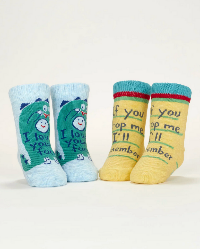 Two pair of baby socks displayed on mannequin feet, one pair is blue with an illustrated dino that reads "I Love Your Face" and the other pair is yellow with blue lettering that raed "If you drop me, I'll remember" 