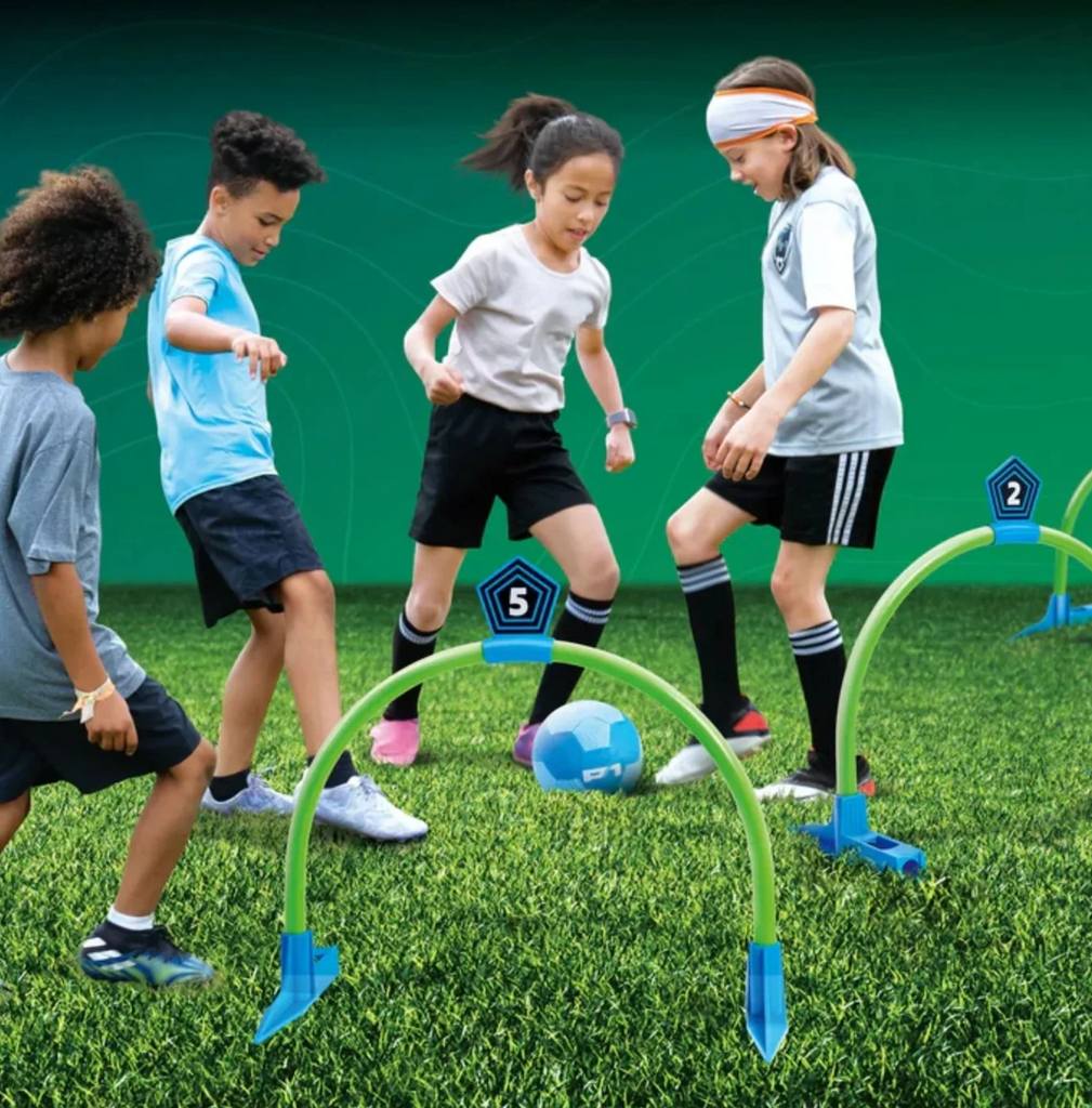 A group of children playing Kick Croquet Strike on a grassy surface. 