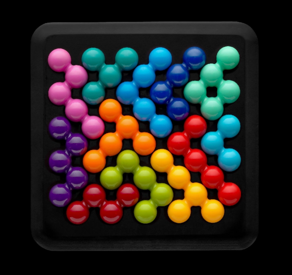 IQ Puzzler Deluxe logic game with the colorful pieces laid flat on the base. 