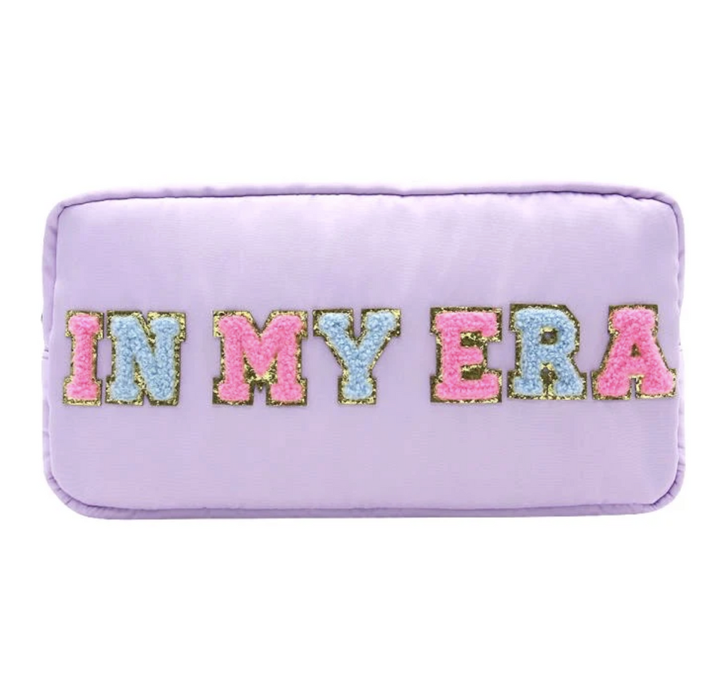 Light purple nylon bag with pink and blue fuzzy letters outlined in gold that read "In My Era"