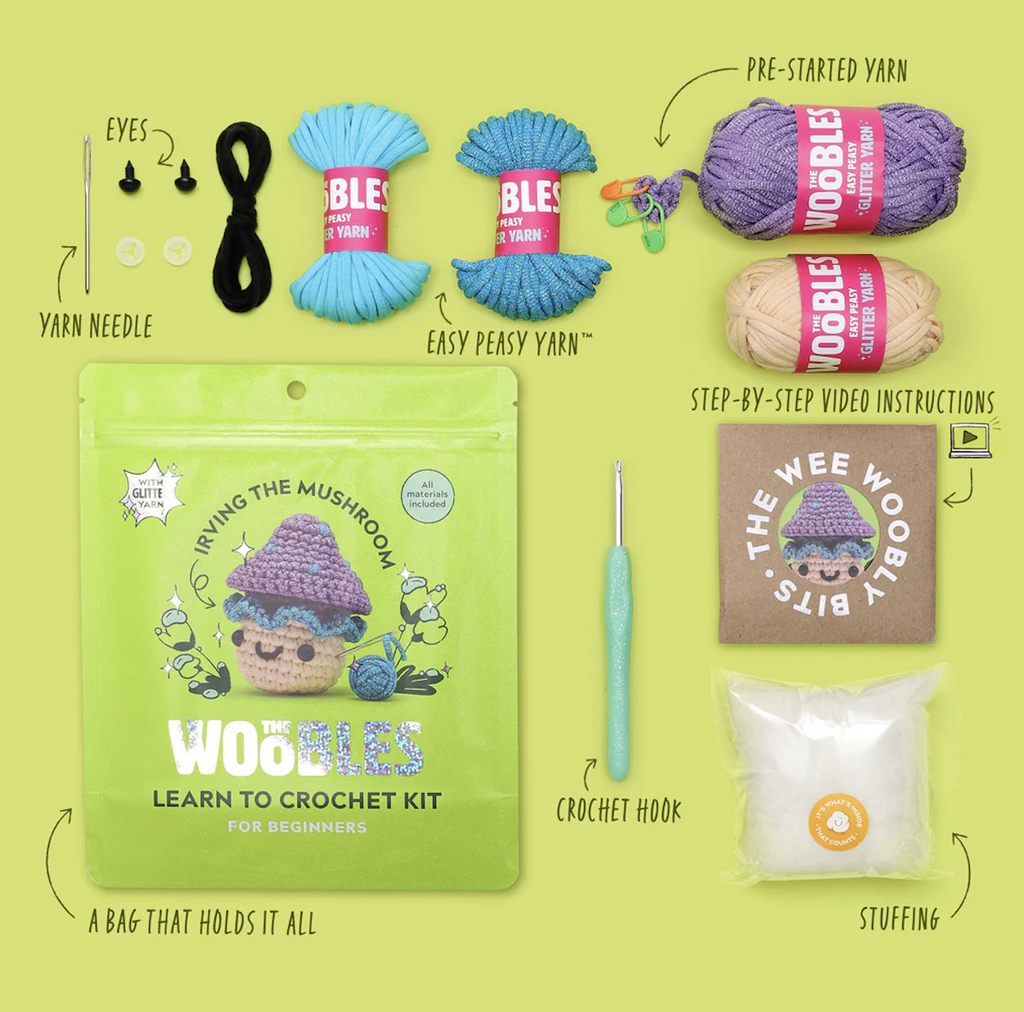 Irving the Mushroom Crochet Kit with five different colors of yarn, a yarn needle, plastic eyes, stuffing, and a crochet hook that all come packaged in a green bag with a picture of a completed Irving.  