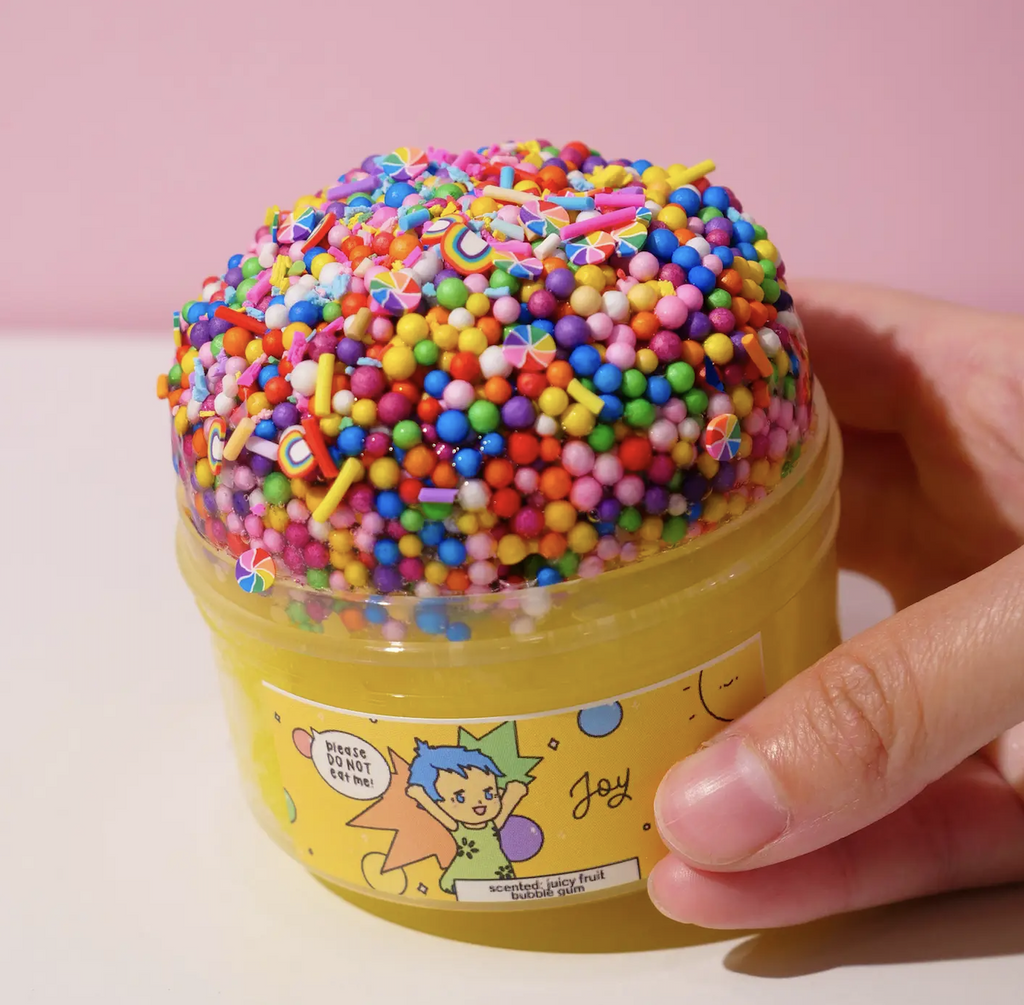 Yellow Joy slime overflowing with rainbow confetti sprinkles. (Not food)