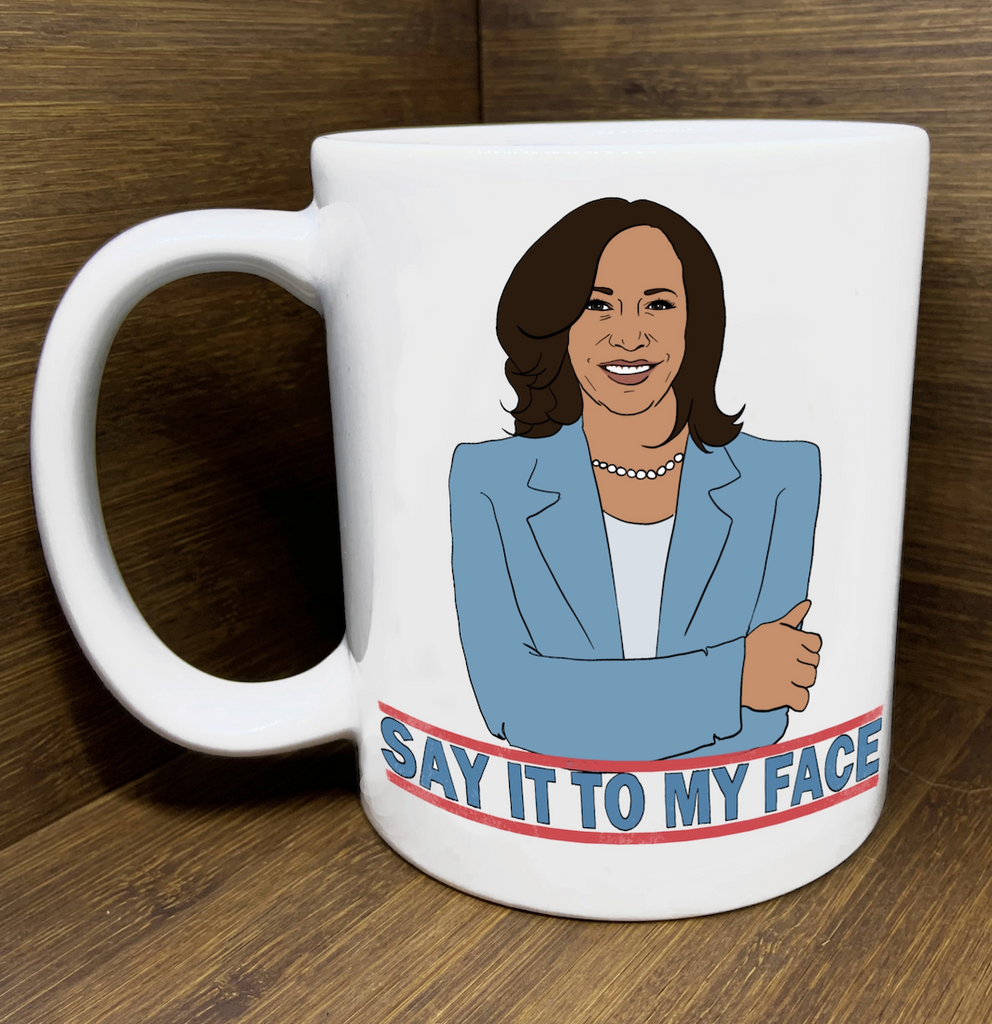 White ceramic mug with illustrated image of Kamala Harris that reads Say It To My Face. 