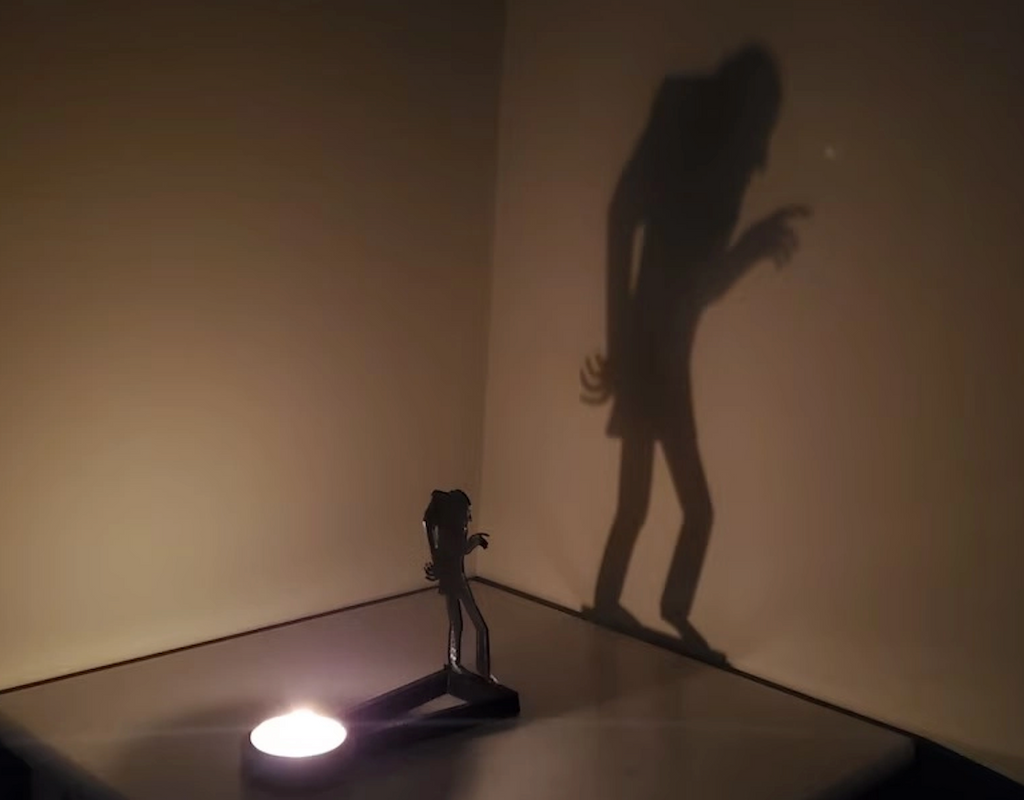 Nosferatu Shadow Caster projecting the shadow of the vampire on the wall as the tea light in the holder is lit and the room is darkened. 