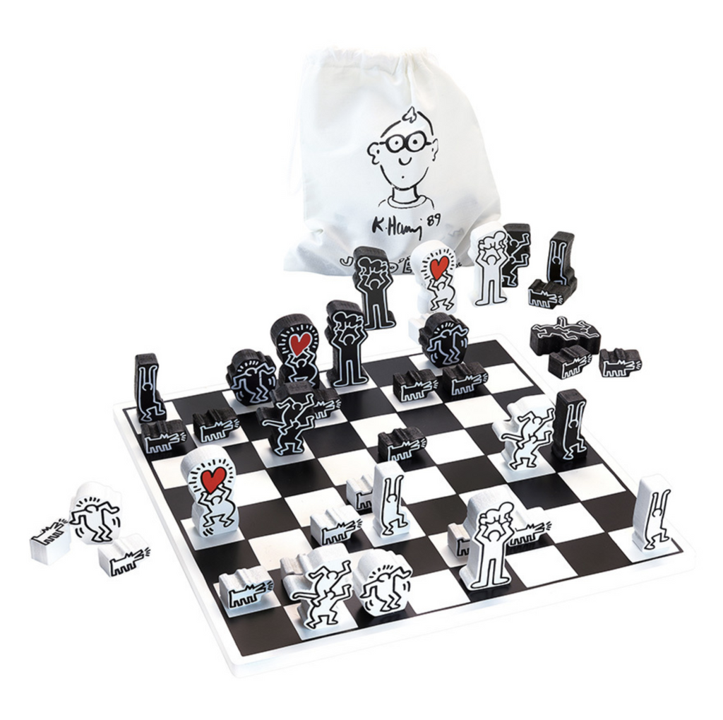Black and white wooden chess set featuring the art of Keith Haring on a white background.