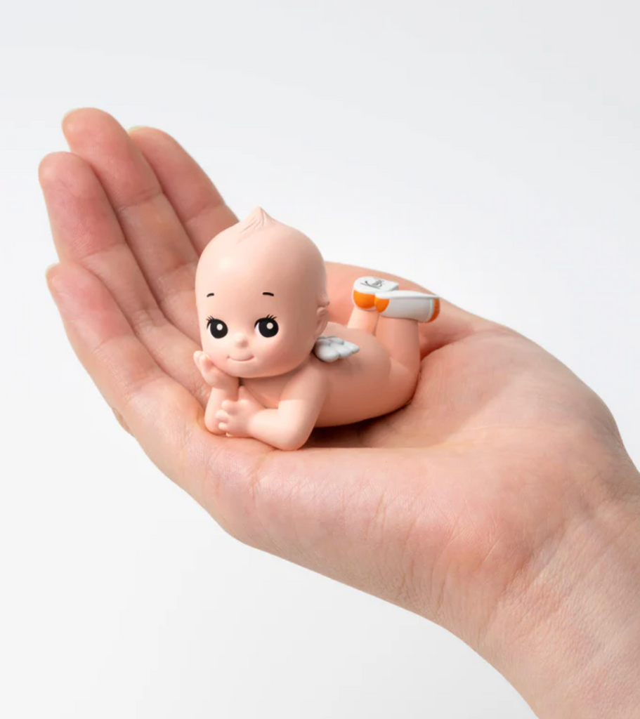 Hand holding Kewpie doll figure.