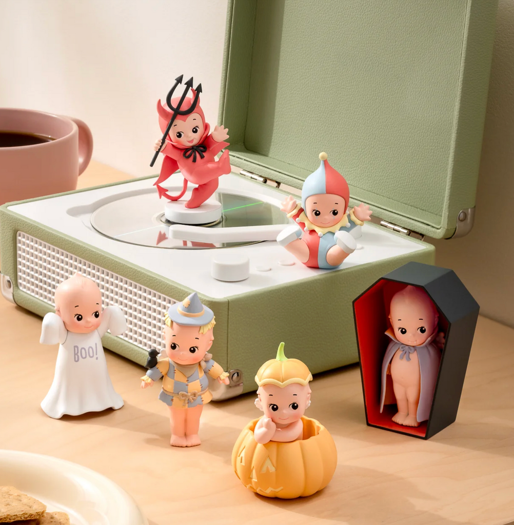 Six Kewpie Halloween figures placed on a table top and green turntable. There is a a devil, jester, ghost, scarecrow, vampire and a kewpie in a pumpkin. 