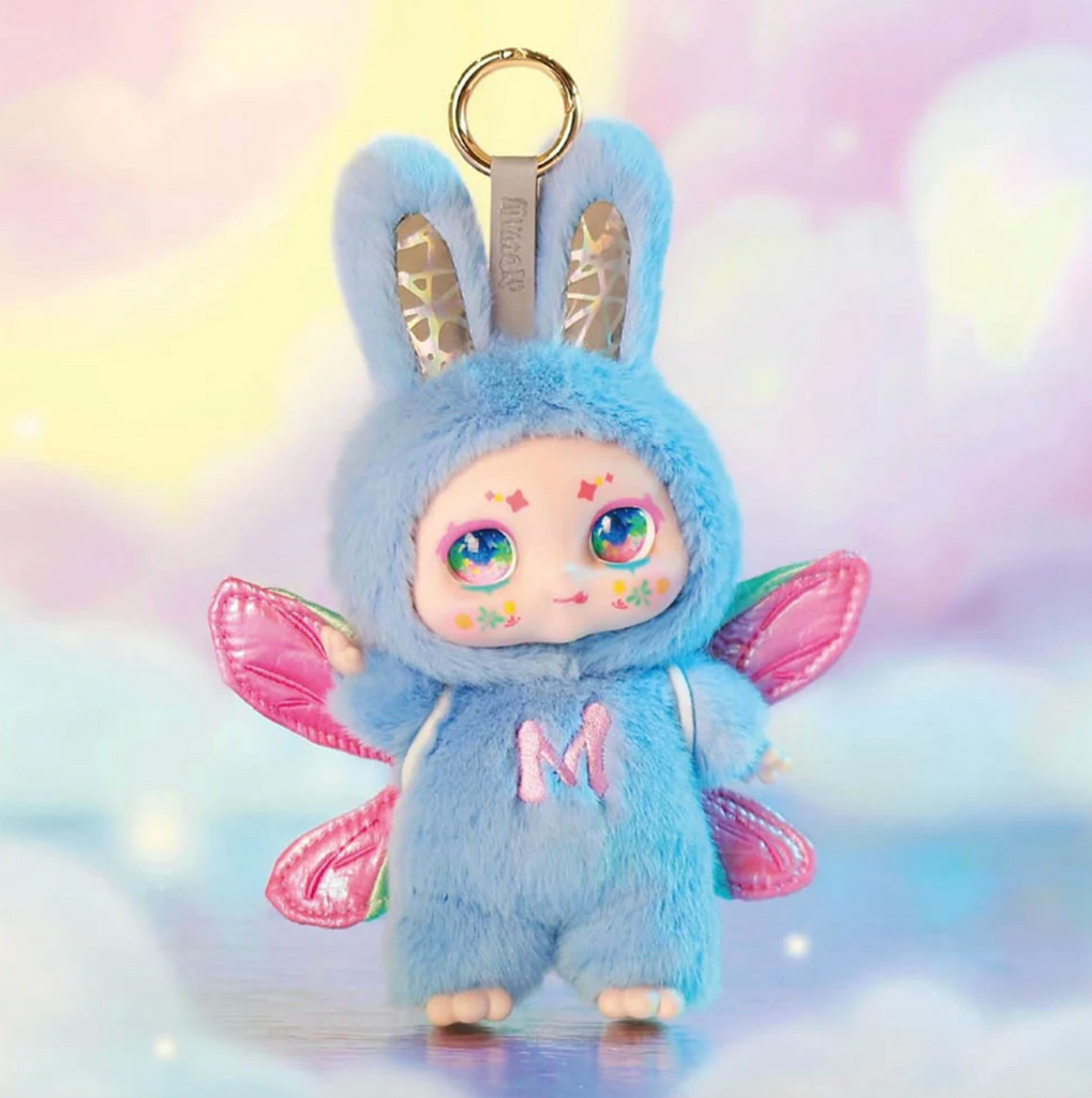 Close up of a Kimmon Dream Maker figure featuring a blue plush toy with pink butterfly wings and rainbow eyes, with a round hook that can be used to attach to your bag or backpack. 