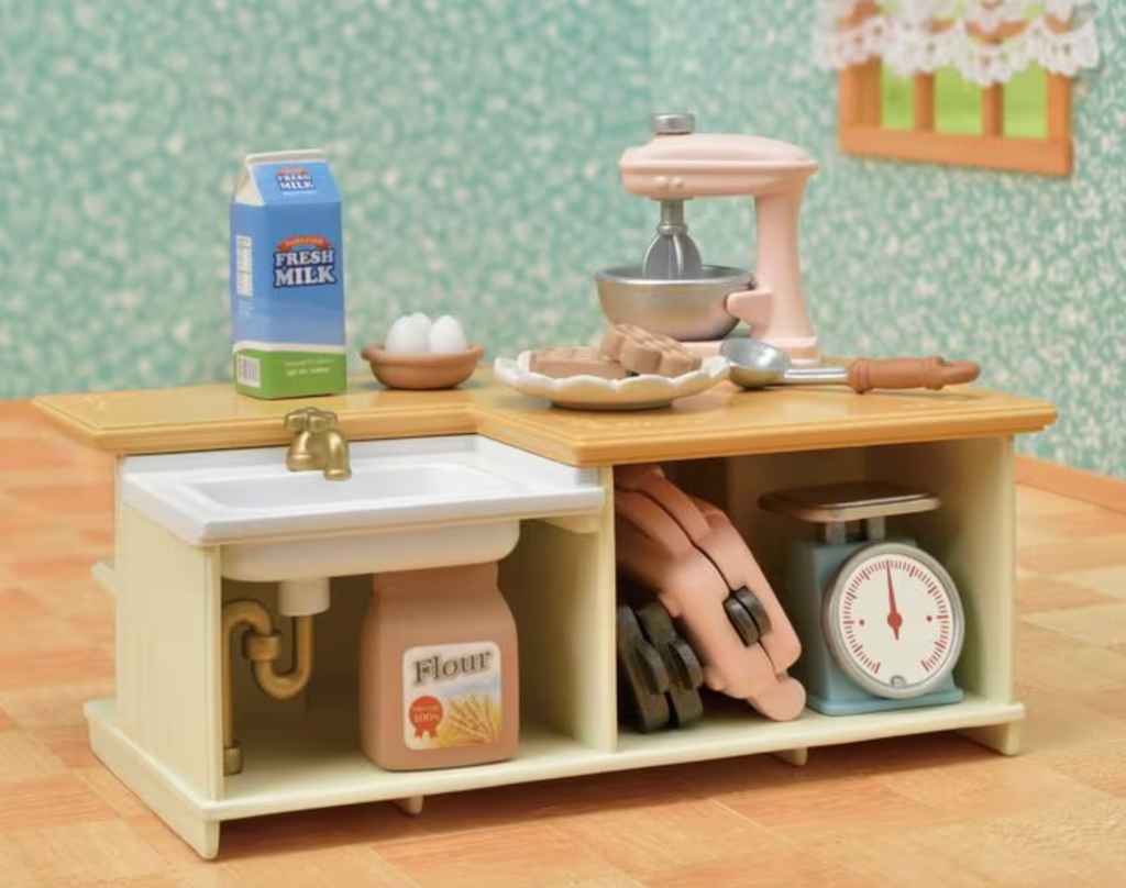 The Kitchen Island from Calico Critters set up in a dollhouse stocked with the included accessories. 