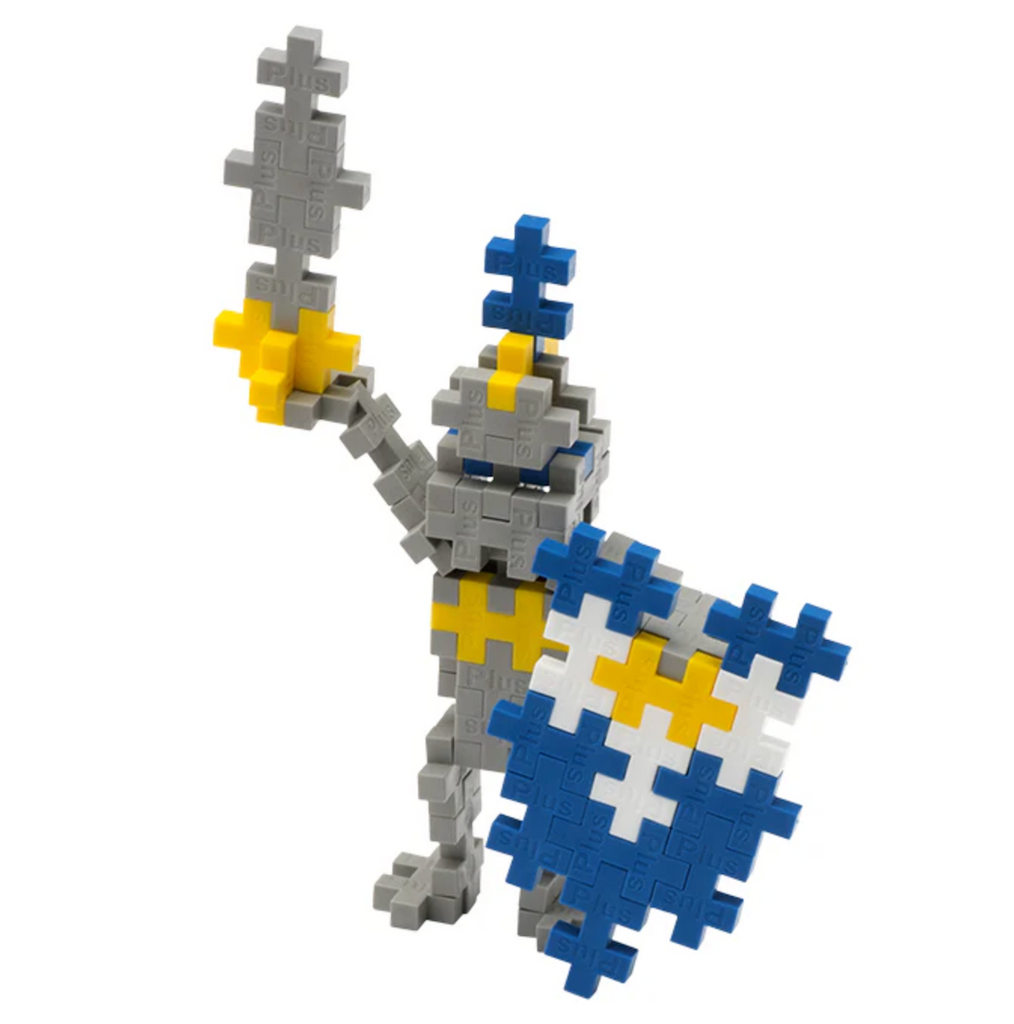 Close up picture of a gray and yellow knight holding a blue and white shield built from the Plus Plus 70 Piece Knight tube. 