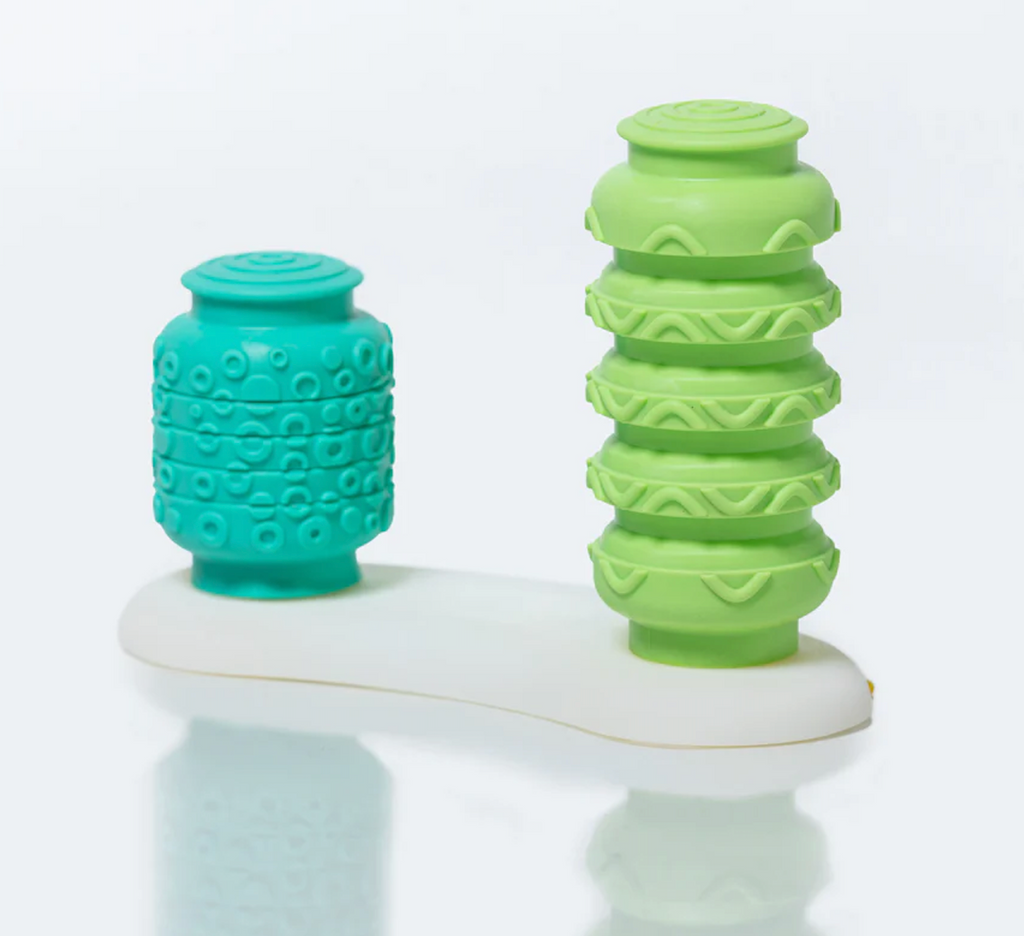 Two textured Krumples, one green and one turquoise, on a white base. Push one down and the other pops up!