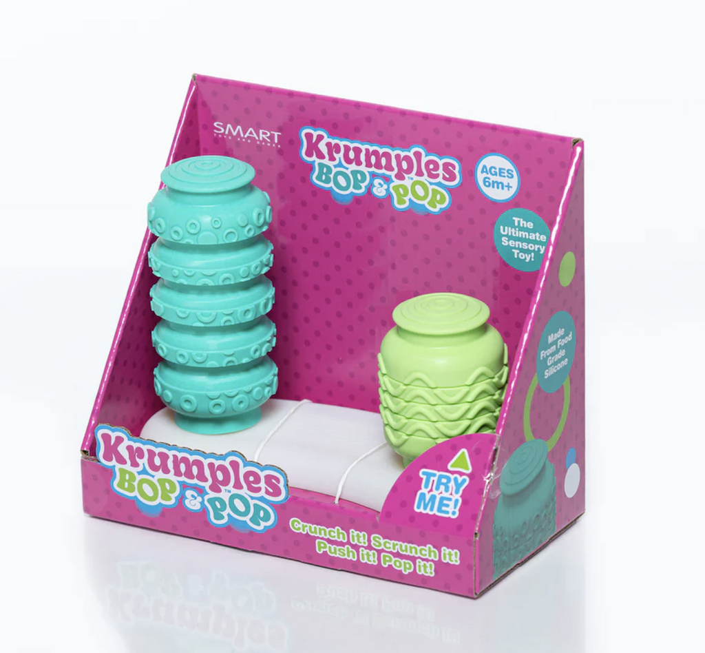 The Krumples Bop and Pop toy packaged in an open purple, box so that the toy can be played with while in the package. The silicone textured Krumples are light green and turquoise, when one is pushed down the other pops up.  
