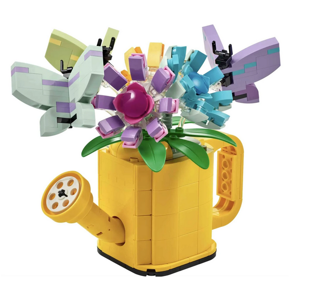 Brick-built yellow watering can toy with a handle and spout. It’s filled with 3 flower toys with movable petals and 3 butterfly toys.
