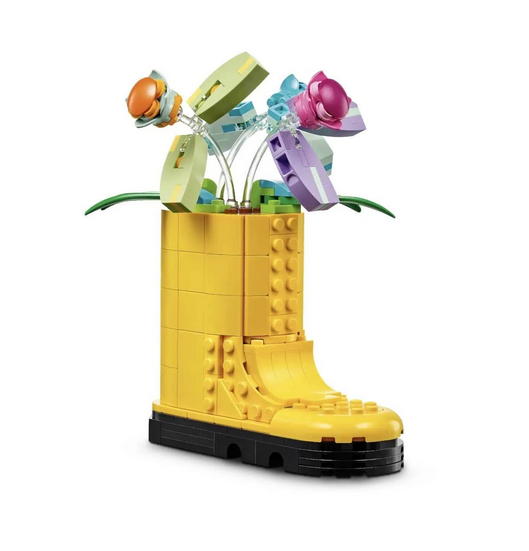 Brick built yellow rain boot filled with 3 flowers with movable petals. 