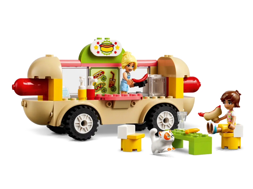 The fully built Hot Dog Truck set which includes a minifigure serving hot dogs with condiments and a minifigure and their cat eating at the table. 