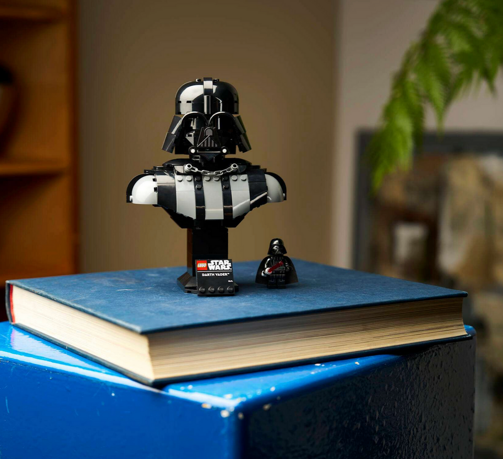 LEGO Star Wars Darth Vader Bust displayed atop a stack of books, complete with the nameplate and minifigure that is included in the building set. 