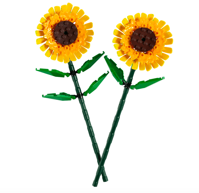 Close up of two brick built sunflowers with green leaves and stems. 