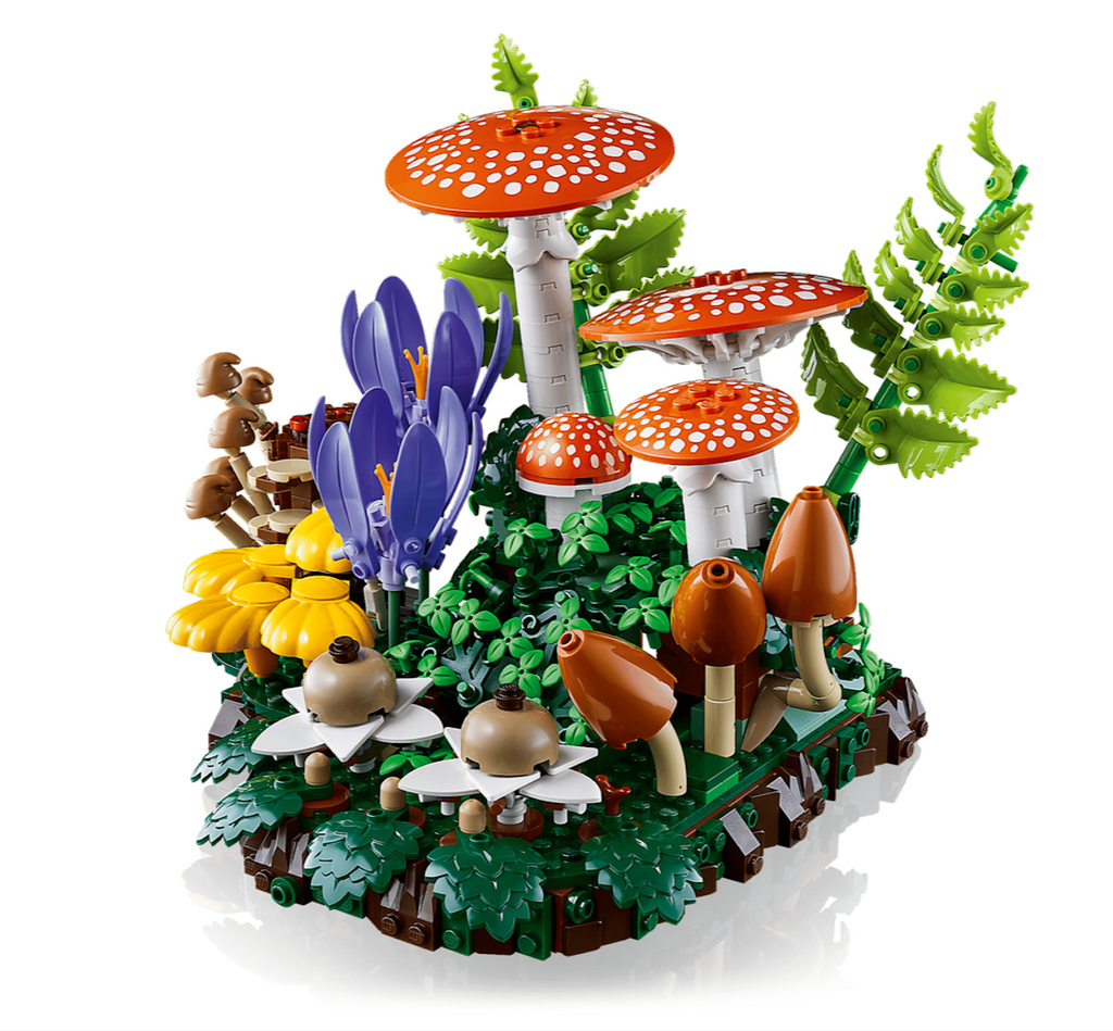 A close up view of the LEGO Woodland Mushroom set featuring red-capped mushrooms with white spots, purple flowers, green ferns, and brown mushrooms on a forest-themed base. 